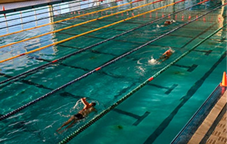 On the image is the pool of the Naval Academy of 
                            Valparaiso. There are seven lanes, and in the second 
                            one, two athletes are swimming. On the third lane there 
                            is a third swimmer.
